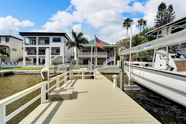 dock area with a water view and a balcony