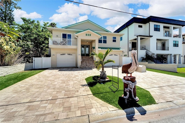 view of front of home featuring a balcony, a garage, and a front yard