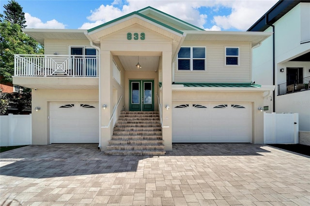 view of front of house featuring a garage, french doors, decorative driveway, and a standing seam roof