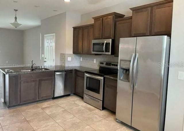 kitchen with dark brown cabinets, backsplash, decorative light fixtures, sink, and appliances with stainless steel finishes