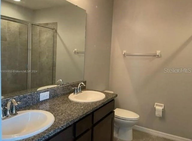 bathroom featuring vanity, toilet, an enclosed shower, and tile patterned floors