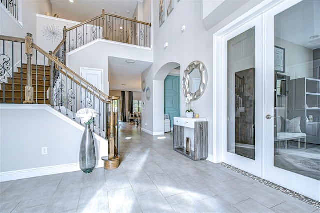 entrance foyer featuring a towering ceiling and french doors