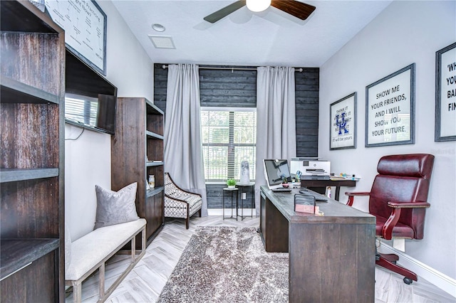 office featuring light hardwood / wood-style flooring, ceiling fan, and a textured ceiling