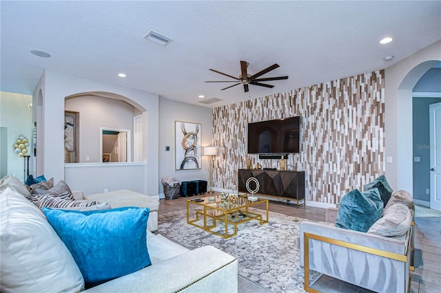 living room with ceiling fan and a textured ceiling