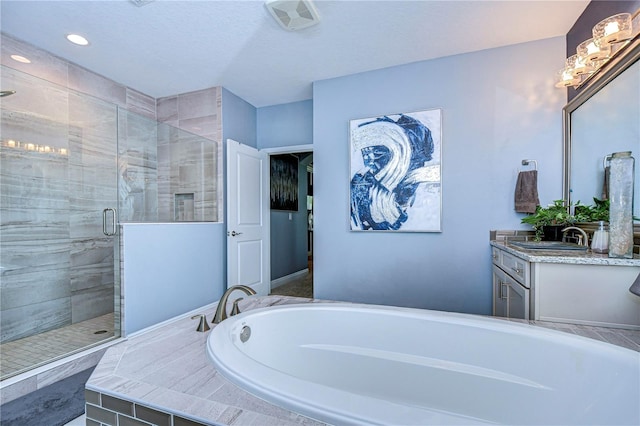 bathroom featuring a textured ceiling, vanity, and shower with separate bathtub