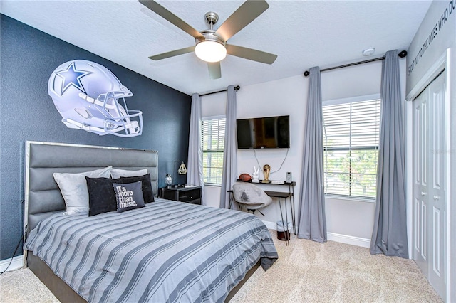 bedroom with carpet, a textured ceiling, ceiling fan, and a closet