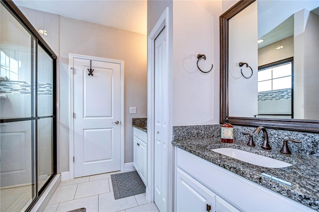 bathroom with tile patterned flooring, walk in shower, and vanity