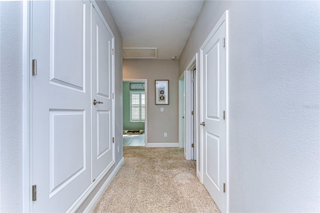 hallway featuring light colored carpet