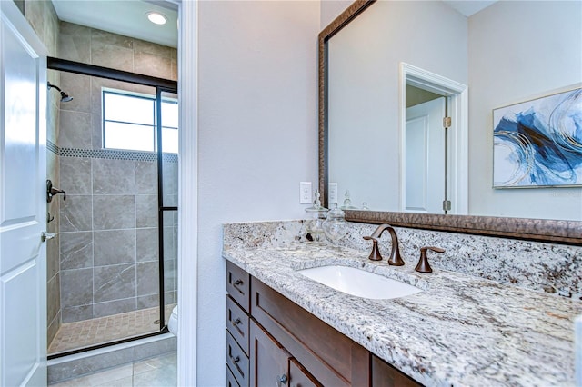 bathroom with vanity, an enclosed shower, and tile patterned floors