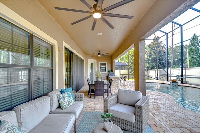 view of patio featuring a lanai, ceiling fan, a fenced in pool, and an outdoor living space