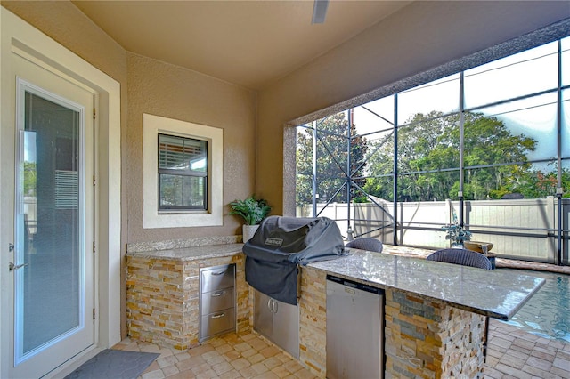 view of patio / terrace with a grill, an outdoor kitchen, and a lanai