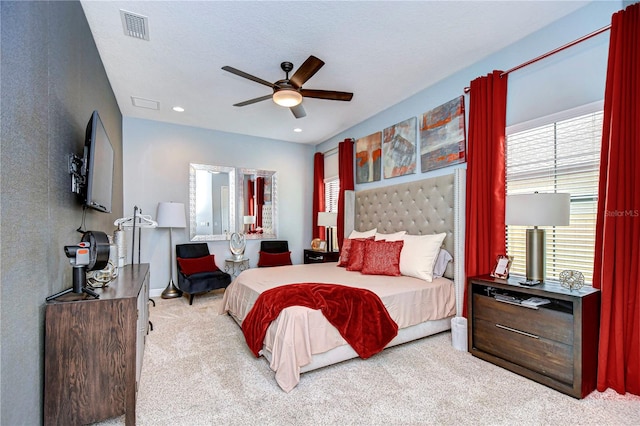 bedroom featuring a textured ceiling, light colored carpet, and ceiling fan