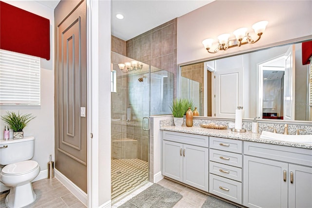 bathroom with vanity, toilet, tile patterned floors, and a shower with door