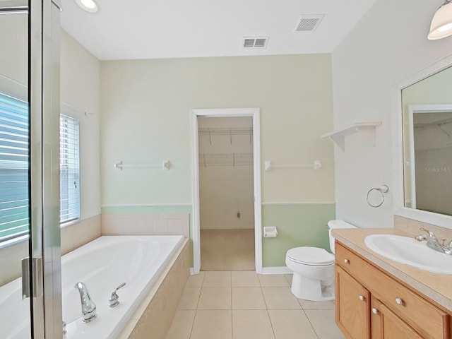 bathroom with visible vents, toilet, a bath, tile patterned floors, and vanity