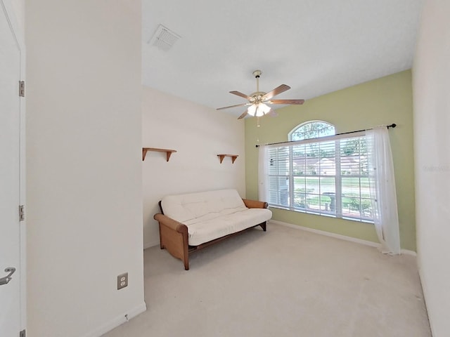 living area featuring visible vents, baseboards, a ceiling fan, and carpet flooring