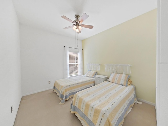 bedroom featuring a ceiling fan, baseboards, and light carpet