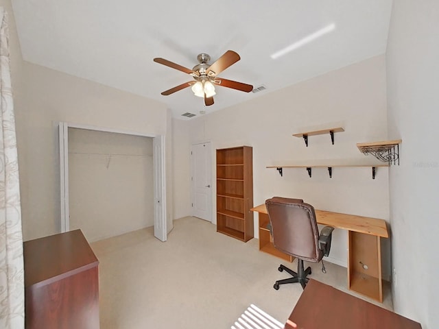 office space with light carpet, visible vents, and ceiling fan