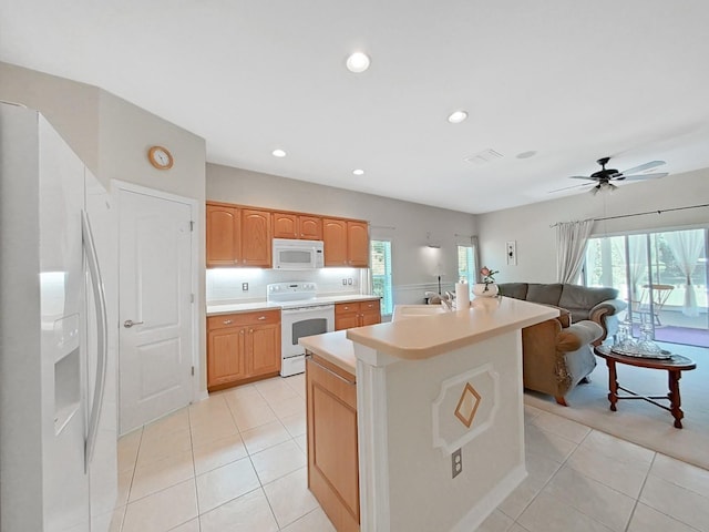 kitchen featuring light tile patterned floors, plenty of natural light, white appliances, and light countertops