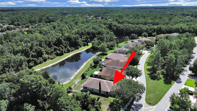 birds eye view of property with a view of trees and a water view