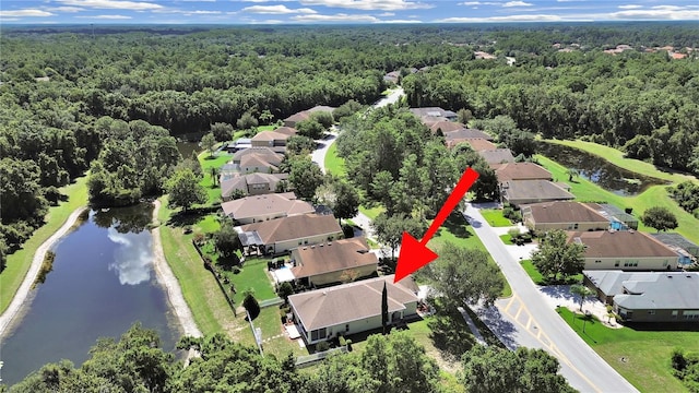 aerial view featuring a residential view, a wooded view, and a water view