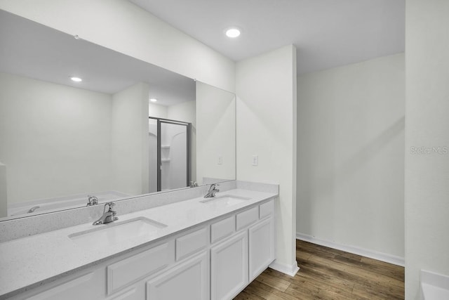 bathroom featuring vanity, wood-type flooring, and a shower with shower door