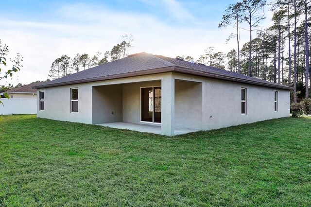 back of house featuring a patio area and a yard