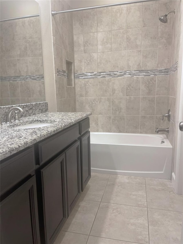 bathroom featuring tiled shower / bath combo, tile patterned flooring, and vanity