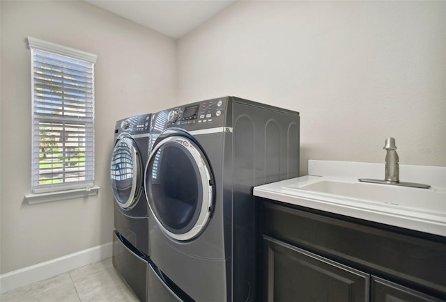 laundry room featuring sink, cabinets, light tile patterned floors, and washing machine and clothes dryer