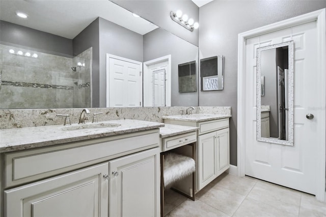 bathroom with a shower, tile patterned flooring, and vanity