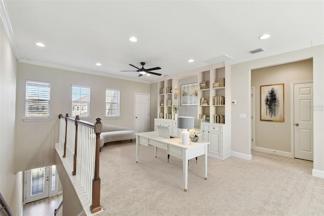 carpeted home office with built in features, ceiling fan, and crown molding