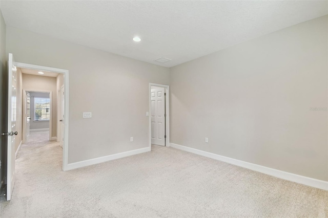 unfurnished room featuring light carpet