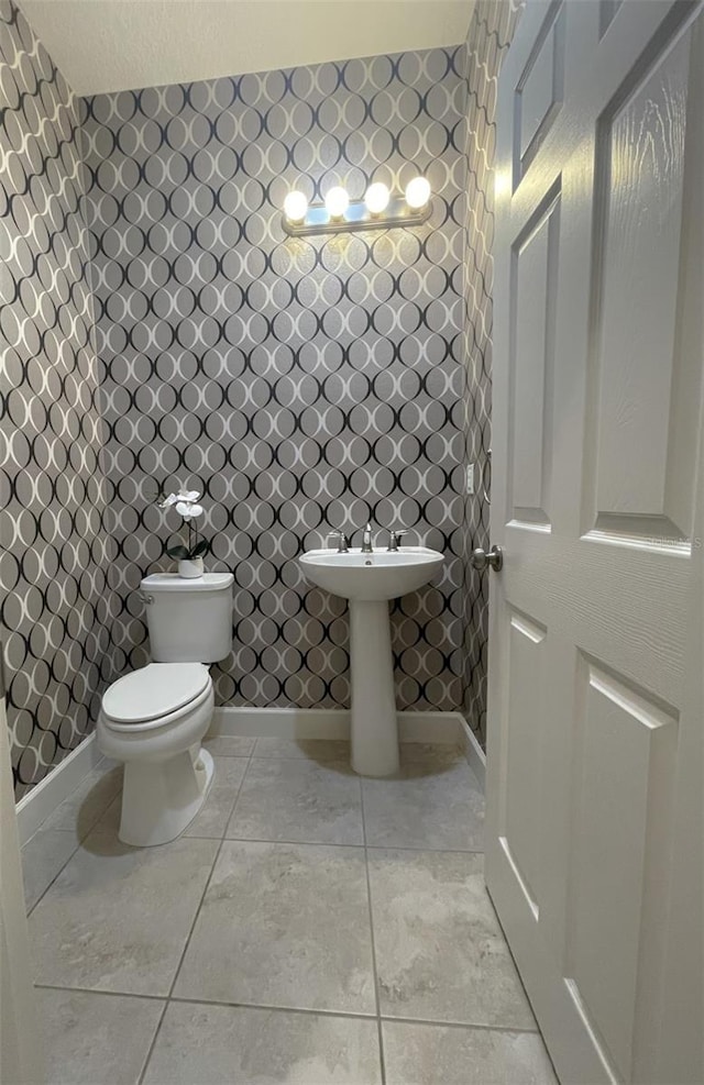 bathroom with toilet and tile patterned flooring