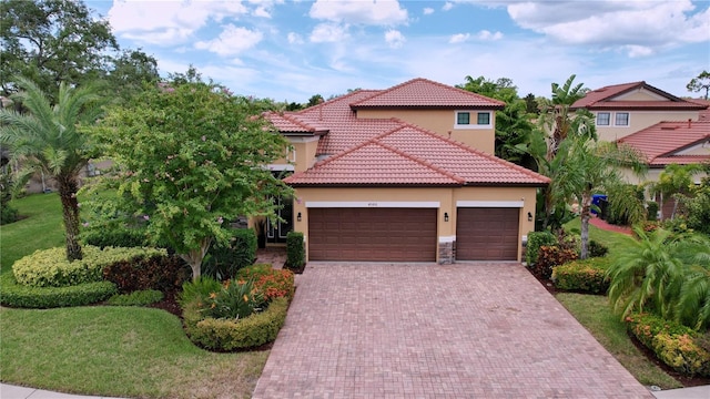 mediterranean / spanish home with a front yard and a garage