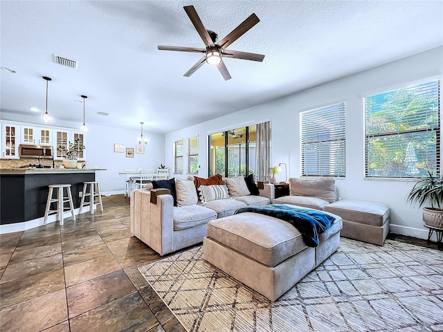 living room featuring a textured ceiling and ceiling fan