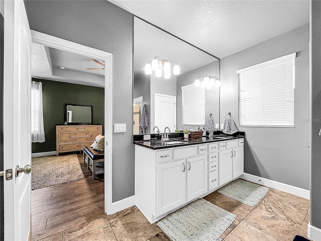 bathroom with vanity, a textured ceiling, hardwood / wood-style flooring, and ceiling fan