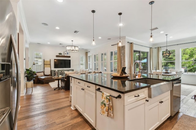 kitchen featuring hanging light fixtures, sink, white cabinetry, appliances with stainless steel finishes, and crown molding