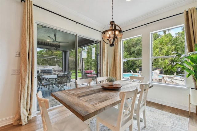 dining area featuring light wood-type flooring, a chandelier, and crown molding