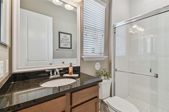 bathroom with walk in shower, vanity, and toilet