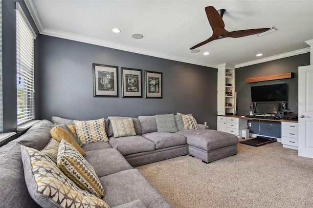 living room featuring ornamental molding, built in desk, ceiling fan, and carpet floors