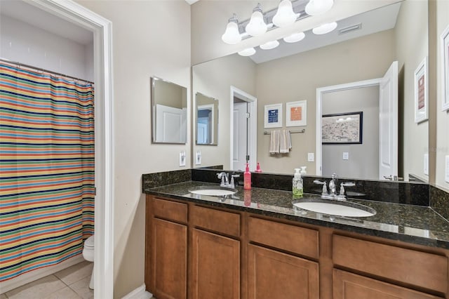 bathroom with walk in shower, vanity, toilet, and tile patterned floors