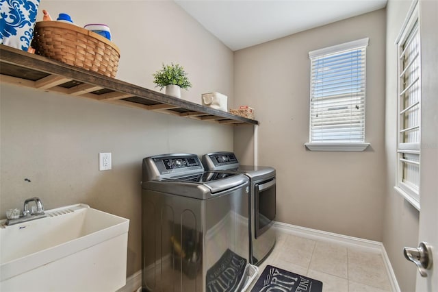 laundry area featuring independent washer and dryer, light tile patterned floors, and sink