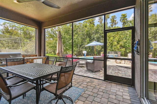 sunroom featuring ceiling fan