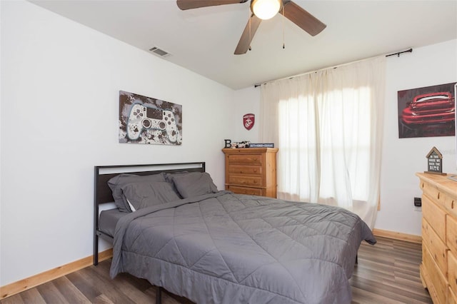 bedroom with multiple windows, ceiling fan, and dark hardwood / wood-style flooring