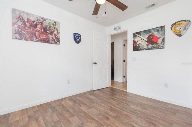 empty room with ceiling fan and hardwood / wood-style floors