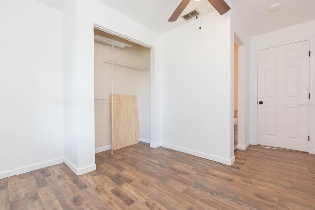 unfurnished bedroom featuring ceiling fan, a closet, and wood-type flooring