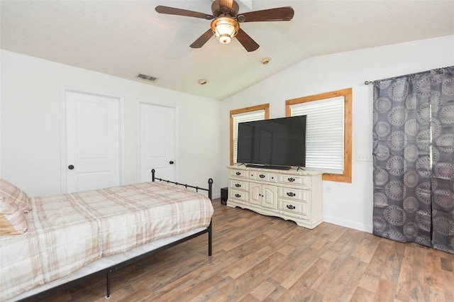 bedroom with hardwood / wood-style floors, ceiling fan, and vaulted ceiling