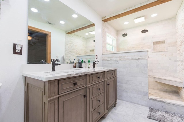 bathroom with vanity, beamed ceiling, and tiled shower