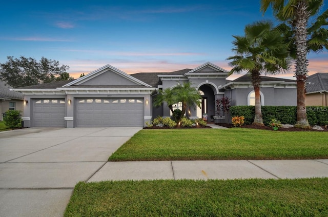 view of front of home with a lawn and a garage