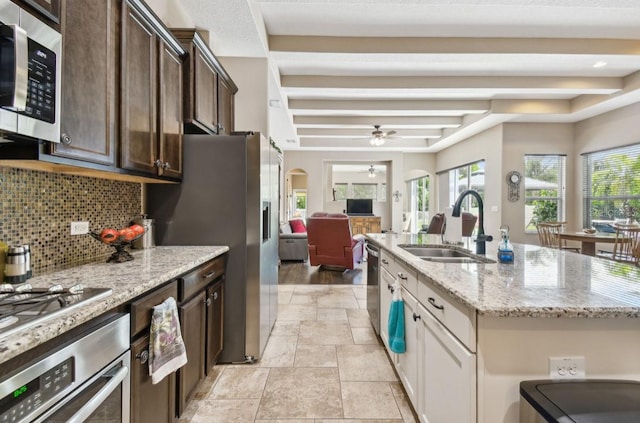 kitchen with dark brown cabinets, appliances with stainless steel finishes, sink, ceiling fan, and light wood-type flooring