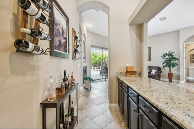 bar featuring light stone countertops and light tile patterned flooring